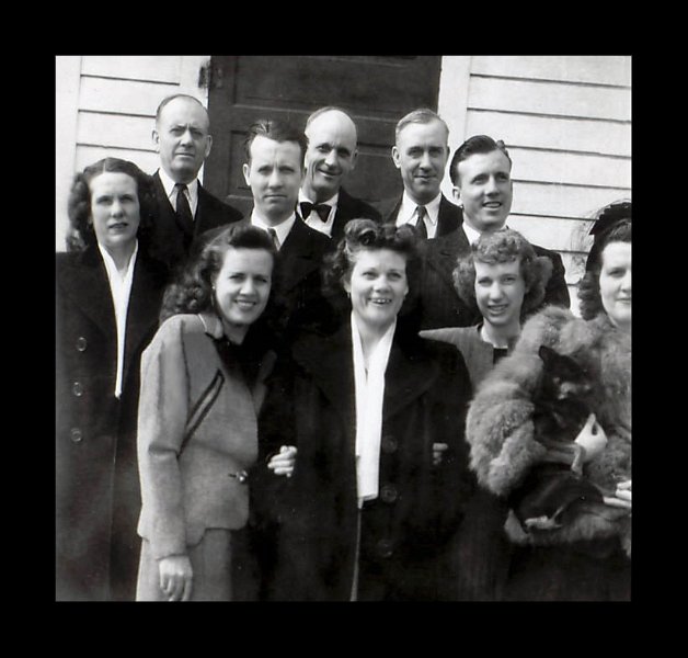 image069.jpg - 1947. Children gather for the funeral of Charles Kaiser. The four ladies in the front row (L to R): Ruth ("Toots", 1906-1987), Laura ("Bobby", 1900-1989), Helen ("Honey", 1902-1997) and Vivian ("Babe", 1913-2001) holding the dog. Back row (L to R): Bertha ("Granny" or "Bert", 1904-1986), Henry ("George", 1890-1963), Ray (1911-1996), Walter ("Kid", 1897-1964), Emil ("Doc", 1892-1959), and Charlie ("Sonny", 1915-1992). Charles Sr. was predeceased by three children including Violet ("Missy", 1894-1919 - childbirth), Harry (1895-1908 - train turntable track accident), Frederick ("Freddy", 1908-1922 - hunting accident).