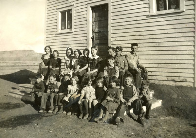 1930sprints001.jpg - Aunt Gwen in center, upper row. Tallest, white collar. One room school house in Breien, ND. Butte in background.