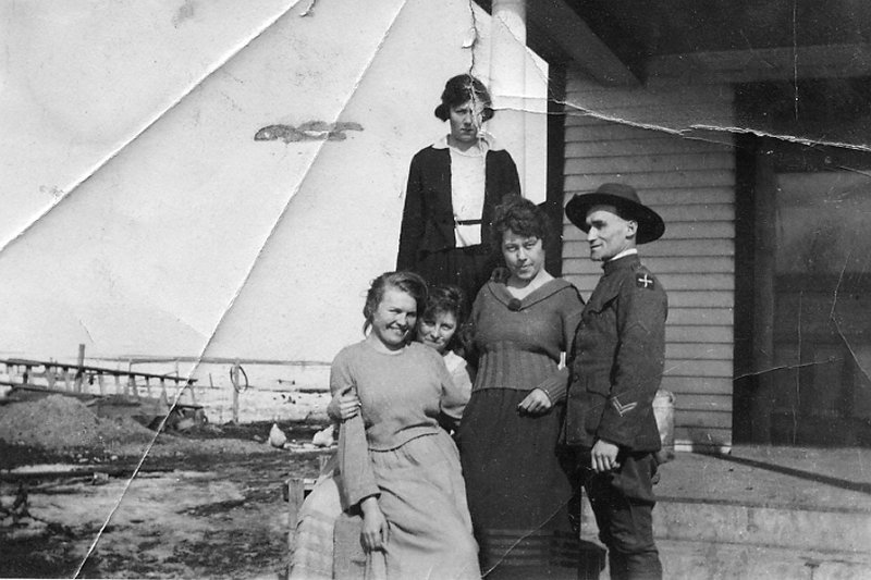 zeltinger010.jpg - Lena Zeltinger sits with Louise Zeltinger in front of her in lower left on Ignatius and Katie Zeltinger farm; the soldier may be Ed Weber, who died in WWI; the woman at the top may be his sister, Dora Brox; the other woman is unknown.