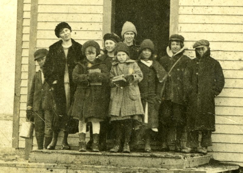 zeltinger025.jpg - Photo from Laura and Matt Zeltinger's estate. One room school house, Tolley, ND. The school was known as the Zeltinger school, as it was on land donated by John Zeltinger.  It stood on top ot the hill derelict until about 2000.  It was a real landmark. Ignatius Zeltinger's daughter, Lena (Zeltinger) Resch is the teacher on the left. Lena taught there for at least two years. Lena's sister, Marie Zeltinger, is standing next to her, and another of Lena's sister, Otillie "Tillie" Zeltinger, is the middle girl in the front. See previous photo.