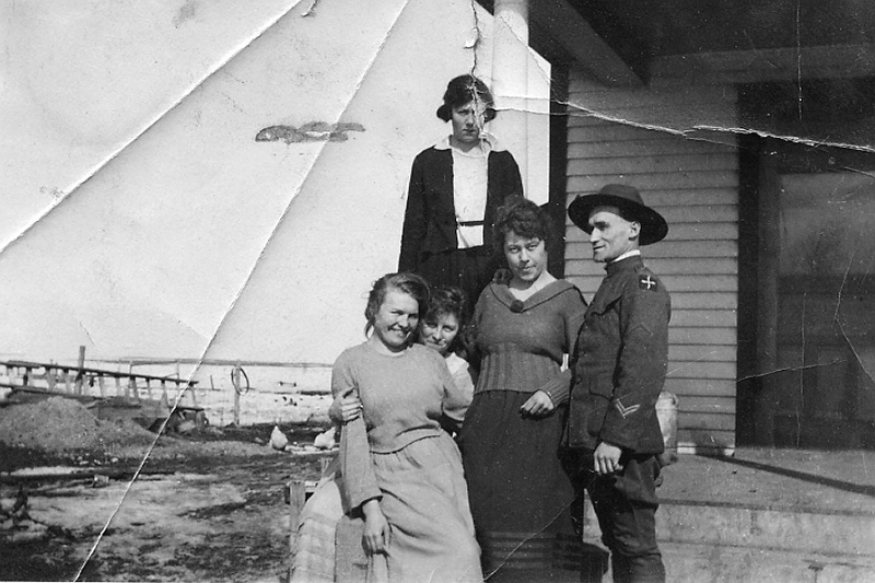 zeltinger010.jpg - Lena Zeltinger sits with Louise Zeltinger in front of her in lower left on Ignatius and Katie Zeltinger farm; the soldier may be Ed Weber, who died in WWI; the woman at the top may be his sister, Dora Brox; the other woman is unknown.