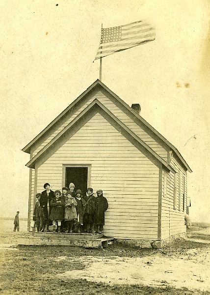 zeltinger024.jpg - Photo from Laura and Matt Zeltinger's estate. One room school house. The school was known as the Zeltinger school, as it was on land donated by John Zeltinger.  It stood on top ot the hill derelict until about 2000.  It was a real landmark. Ignatius Zeltinger's daughter, Lena (Zeltinger) Resch is the teacher on the left. Lena taught there for at least two years. Lena's sister, Marie Zeltinger, is standing next to her, and another of Lena's sister, Otillie "Tillie" Zeltinger, is the middle girl in the front. See next photo for closeup.